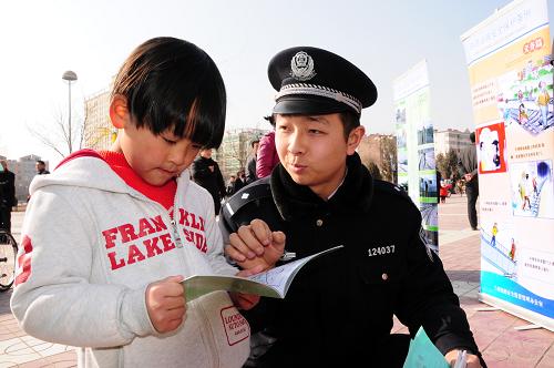 2月22日,在甘肅省蘭州市皋蘭縣文化廣場舉行的農(nóng)村廟會上,蘭州鐵路公安處蘭州東車站派出所的民警王康為小學(xué)生講解鐵路安全常識。新華社記者 范培珅 攝