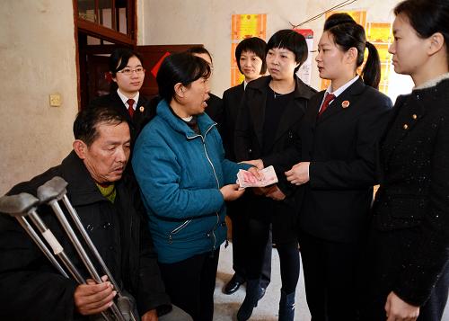 3月7日,福清市婦女干部將捐款送到南厝村特困家庭陳華僑(左一)夫婦手中。新華社記者 張國俊 攝