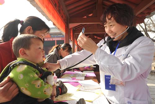 臨汾市人民醫(yī)院的醫(yī)生在給孩子義診(3月7日攝)。3月7日,山西省臨汾市文化、科技、衛(wèi)生“三下鄉(xiāng)”活動(dòng)在襄汾縣丁村文化廣場(chǎng)啟動(dòng)。臨汾市組織衛(wèi)生、農(nóng)業(yè)、文化、科技、司法等13個(gè)系統(tǒng)的200多人深入基層,為廣大農(nóng)民服務(wù)。新華社記者 范敏達(dá) 攝