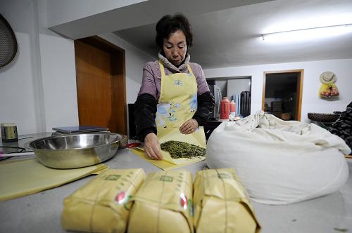 3月25日,在杭州市西湖區(qū)龍井村,一位茶農(nóng)正在用牛皮紙和宣紙包裝茶葉。 新華社記者 鞠煥宗 攝