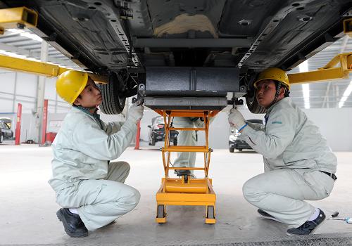 新鄉(xiāng)市新能電動汽車有限公司的工作人員在為電動汽車安裝動力電池(4月16日攝)。新華社記者 李博 攝