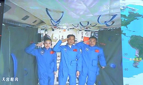 6月24日,中共中央總書記、國家主席、中央軍委主席習(xí)近平來到北京航天飛行控制中心,同正在天宮一號(hào)內(nèi)執(zhí)行任務(wù)的神舟十號(hào)航天員聶海勝、張曉光、王亞平通話。這是航天員在敬禮。 新華社記者李濤攝