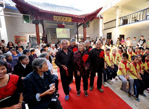 10月12日,在浙江省臺(tái)州市路橋區(qū)管前村的九九重陽(yáng)敬老禮活動(dòng)現(xiàn)場(chǎng),金婚老人們踏上紅地毯。連日來,浙江各地鄉(xiāng)村利用根據(jù)不同鄉(xiāng)鎮(zhèn)的傳統(tǒng)文化特點(diǎn)建設(shè)的“文化禮堂”,開展九九重陽(yáng)敬老禮活動(dòng)。 新華社記者 王小川 攝