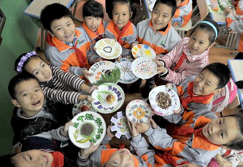 10月15日,翠庭園小學(xué)的同學(xué)們?cè)谡故舅麄冇H手制作的倡導(dǎo)節(jié)約精神的“光盤(pán)”。新華社記者 郭晨 攝