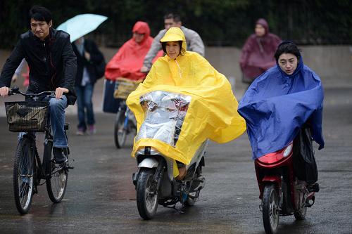 10月15日,人們在南京市北京西路頂著風(fēng)雨騎行。 新華社發(fā)(王躍武 攝)