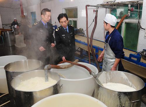 10月15日,在陜西省渭南市合陽(yáng)縣一家豆腐坊,合陽(yáng)縣食品藥品監(jiān)督管理局城區(qū)北所工作人員許鵬(右二)在檢查生產(chǎn)過(guò)程是否達(dá)標(biāo)。新華社記者 丁海濤 攝