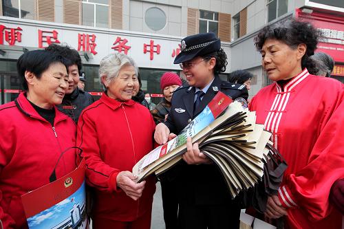 11月14日,棗莊市公安局市中分局文化路派出所民警在立新小區(qū)向參加晨練的居民發(fā)送預(yù)防詐騙宣傳手冊(cè)、新春年畫和環(huán)保購(gòu)物袋等宣傳物品。新華社發(fā)(吉喆 攝)