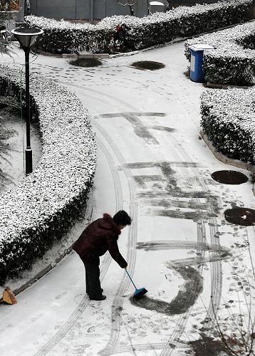 2月7日,一位市民在北京石景山依翠園社區(qū)道路上掃出“下雪了”三個字。當(dāng)日,北京迎來今冬首場降雪。新華社記者 何俊昌 攝