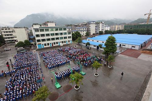5月2日,在四川省雅安市天全縣城區(qū)第一完全小學(xué),學(xué)生們課間在操場上舉行復(fù)課典禮。當(dāng)日,四川省雅安市天全縣第一完全小學(xué)在板房內(nèi)全面復(fù)課。天全縣第一完全小學(xué)有6個年級,共40個班,2502名學(xué)生,是天全縣規(guī)模最大的小學(xué)。地震中該校教學(xué)樓成為危樓,共青團(tuán)湖南省委和湖南省青少年發(fā)展基金會聯(lián)合白沙飛翔公益基金等共同捐建了49間板房,保障全校師生上課和辦公的需要。新華社發(fā)(張曉理 攝)