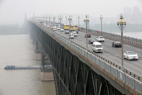 5月7日,車輛在南京長江大橋上行駛。5月15日起,南京長江大橋全天禁止10座(含)以上客車通行,公交車和辦理了通行證的南京市號牌企事業(yè)單位自備通勤班車(含包車通勤車輛)除外,禁行后車輛可繞行南京長江二橋、三橋、長江隧道等過橋。此前,相關(guān)部門已經(jīng)發(fā)布消息:5月15日前對違反禁令車輛只告知不處罰,15日后將罰款100元扣3分。 1968年建成通車的南京長江大橋是南京地區(qū)唯一免費過江通道,近年來多次維修,但一直沒有條件大修,雖然南京市先后推出外地號牌限行、本地大貨車限時等措施降低橋梁負(fù)荷,但目前每天過往大橋的車輛仍有七、八萬輛,大橋管理部門認(rèn)為,進一步降低大橋負(fù)荷是保證橋梁安全的關(guān)鍵所在。新華社發(fā)