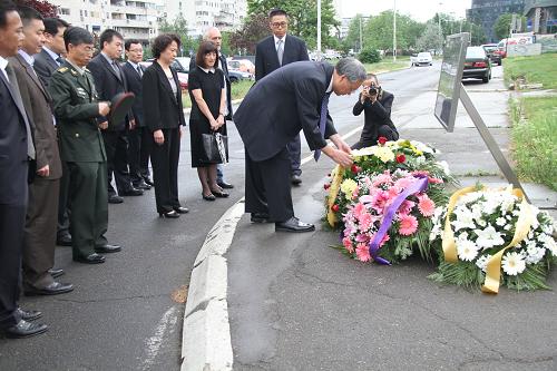 5月7日,在塞爾維亞首都貝爾格萊德,中國駐塞爾維亞大使張萬學(xué)在紀(jì)念碑前整理花圈上的挽聯(lián)。新華社記者 汪慧 攝
