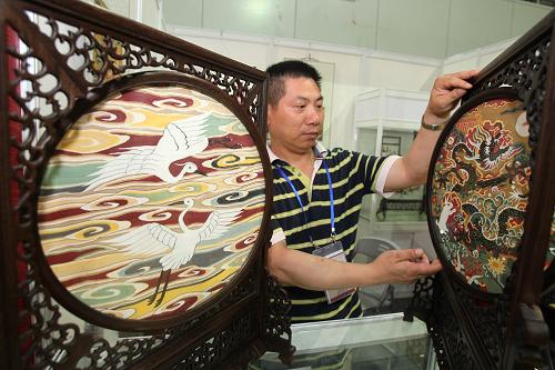 5月27日,蘇州緙絲世家的非遺傳承人在整理緙絲工藝品。江蘇省非物質文化遺產技藝大展將于5月28日在南通體育會展中心開幕。此次大展以傳承人現場演示、展品陳列和圖文展板相結合的形式進行,共匯集全省各地非物質文化遺產傳統(tǒng)技藝、美術類項目101項,分為剪刻畫繪、木作編扎、雕鐫塑作、織染紉繡、食品釀造5個展區(qū)。新華社發(fā)(許叢軍 攝)