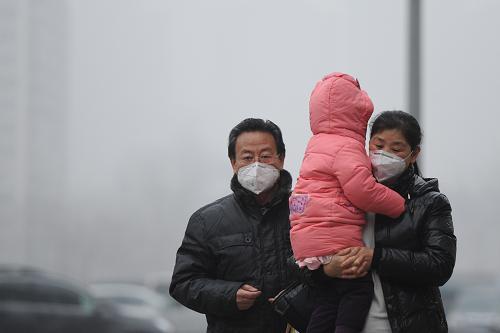 1月23日,幾名戴口罩的市民行走在大霧彌漫的北京東三環(huán)街道上。新華社記者 羅曉光 攝