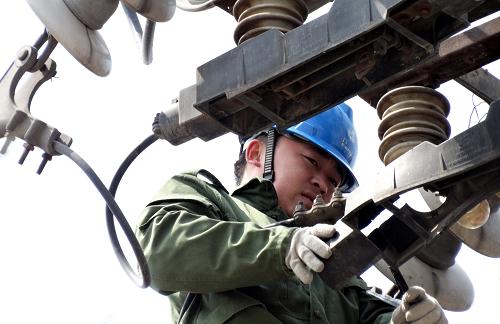 4月22日,北京電力公司的技術(shù)人員在朝陽北路進行輸電線路設(shè)備更新。新華社記者 李欣 攝
