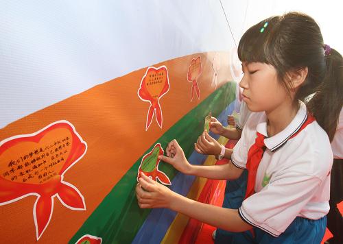 5月31日,學(xué)生們?cè)趶執(zhí)麑懹性竿?#8220;紅領(lǐng)巾夢(mèng)想卡”。新華社記者 賴向東 攝