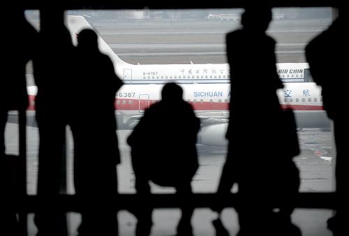 2012年1月20日,旅客在成都雙流機(jī)場通過玻璃窗觀看飛機(jī)起降,等候登機(jī)。當(dāng)日,成都雙流機(jī)場航班數(shù)量達(dá)714架次,旅客吞吐量10.2萬人次以上。新華社記者 李橋橋 攝