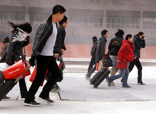 2009年1月23日,上海市鐵路迎來節(jié)前客流高峰,乘客頂著大風(fēng)從鐵路上海站進(jìn)站。新華社發(fā)