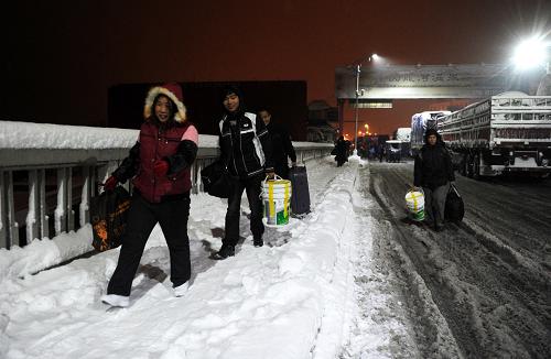 2011年1月20日,湖北黃梅縣的返鄉(xiāng)農(nóng)民工冒著風(fēng)雪從江西九江長江大橋徒步回家。新華社記者 周科 攝