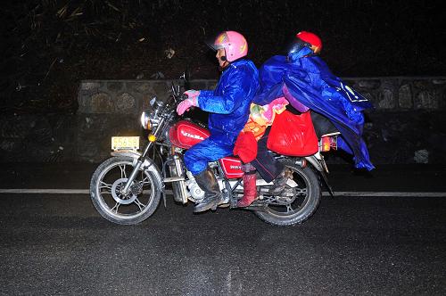 2011年1月19日,在210國道廣西南丹縣境內(nèi),一家三口騎著摩托車在雨中趕路。他們跟隨由數(shù)十人組成的摩托車返鄉(xiāng)隊(duì)伍從廣東出發(fā),驅(qū)車近2000公里回貴州老家過年。新華社記者 黃孝邦 攝
