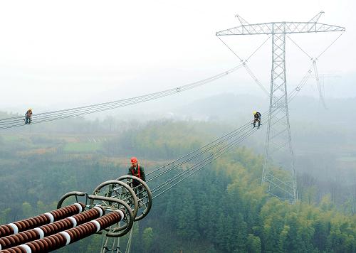 工作人員在對(duì)向家壩—上海±800千伏特高壓直流輸電線路檢修(2012年2月25日攝)。新華社發(fā)