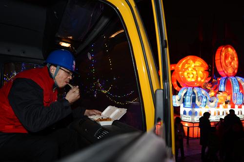 2月20日晚,濟(jì)南供電公司的曹杰飛在應(yīng)急發(fā)電車?yán)锍院酗?。新華社記者 郭緒雷 攝