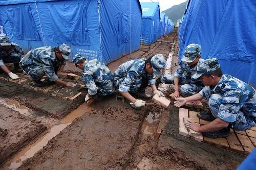 5月9日,成都軍區(qū)空軍官兵在青龍場(chǎng)村集中安置點(diǎn)的帳篷間鋪紅磚。5月8日晚,四川蘆山龍門(mén)鄉(xiāng)遭遇震后最大一場(chǎng)暴雨,青龍場(chǎng)村集中安置點(diǎn)的部分帳篷內(nèi)出現(xiàn)積水。成都軍區(qū)空軍官兵緊急出動(dòng),搶運(yùn)紅磚、砂石,排除積水。目前,安置點(diǎn)的帳篷積水問(wèn)題已解決,700余名村民住進(jìn)帳篷。新華社發(fā)(劉應(yīng)華 攝)