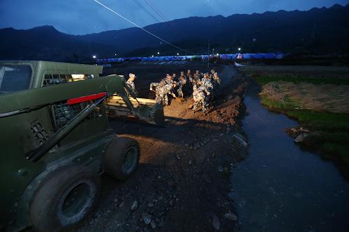 5月9日,成都軍區(qū)空軍官兵在搶修通往安置點(diǎn)的道路。新華社發(fā)(劉應(yīng)華 攝)