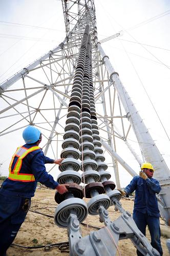 4月10日,在安徽省蕪湖市南陵縣境內(nèi),安徽送變電工程公司施工人員在地面起吊瓷瓶。新華社發(fā)(鄭賢列 攝)