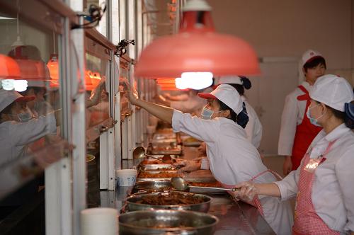 4月12日,江西省華東交通大學(xué)食堂,工作人員在給學(xué)生打飯菜。新華社記者 周密 攝