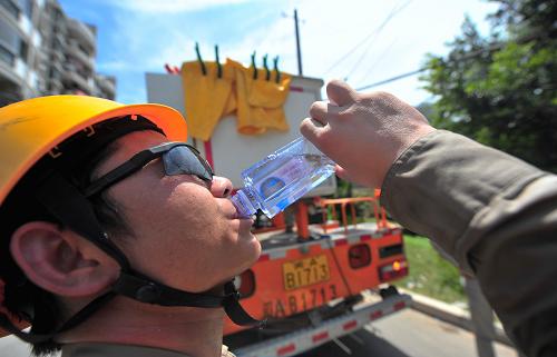 7月8日,電力搶修工在作業(yè)完成回到地面后飲水。新華社記者 魏培全 攝