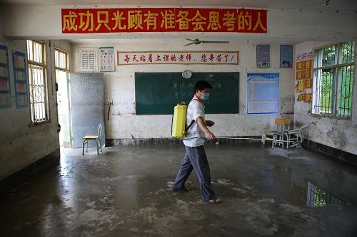 8月27日,廣西象州縣羅秀中學(xué)一名老師在給被洪水浸泡過的教室消毒。新華社發(fā)(龔堅(jiān) 攝)