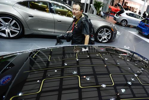 8月30日,參觀者在車展現(xiàn)場參觀一輛“頭頂”太陽能電池板的環(huán)保汽車。新華社記者李橋橋攝