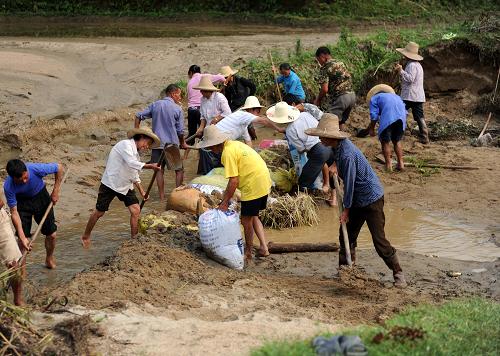 6月12日,江西寧都縣黃陂鎮(zhèn)烏逕村農(nóng)民在搶修被洪水沖毀的水渠。新華社記者 周科 攝