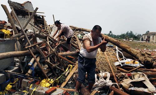 7月8日,安徽省天長市秦欄鎮(zhèn)曹山村受災(zāi)農(nóng)民趙保云在清理被毀房屋。新華社發(fā)(李炳旺 攝)
