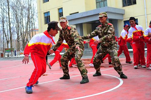 4月12日,玉樹(shù)州八一孤兒學(xué)校的學(xué)生和武警玉樹(shù)州支隊(duì)的官兵一起玩游戲。青海玉樹(shù)“4·14”地震三周年紀(jì)念日來(lái)臨前夕,玉樹(shù)州八一孤兒學(xué)校的15名學(xué)生走進(jìn)武警青海省總隊(duì)玉樹(shù)州支隊(duì)警營(yíng)參觀、學(xué)習(xí)。玉樹(shù)地震后,武警青海省總隊(duì)玉樹(shù)州支隊(duì)經(jīng)常組織官兵看望八一孤兒學(xué)校的學(xué)生,還專門成立了孤兒慈善基金,對(duì)10名藏族孤兒,每月捐助100元,直至他們完成學(xué)業(yè)或長(zhǎng)大成人。新華社發(fā)(李少鵬 攝)