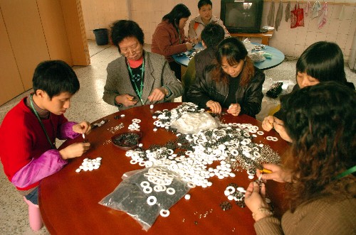 2007年12月3日,幾位智障人士和家長一起在廣州德福之家加工手工藝品。廣州德福之家專門為那些從特殊學(xué)校結(jié)業(yè)后沒有找到工作的人士提供工作及生活技能培訓(xùn)。目前這里聚集著十多位殘疾人,從事一些熱心機(jī)構(gòu)和個(gè)人提供的適合他們的工作,從中體驗(yàn)工作的成就感。 新華社記者 壯錦 攝