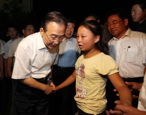 8月21日至22日,中共中央政治局常委、國務院總理溫家寶再次來到舟曲災區(qū),看望受災群眾,慰問堅守救災一線的部隊官兵,實地指導搶險救災和恢復重建工作。這是8月21日晚,溫家寶在舟曲縣第一中學的受災群眾安置點看望受災群眾時,安慰一名小姑娘。 新華社記者 劉衛(wèi)兵 攝