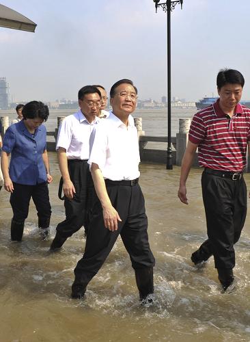 中共中央政治局常委、國務院總理溫家寶近日在湖北考察防汛抗洪工作。這是7月23日,漢口龍王廟險段防洪墻外的觀江平臺已被江水淹沒。溫家寶趟著一尺深的江水察看汛情。新華社記者 黃敬文 攝