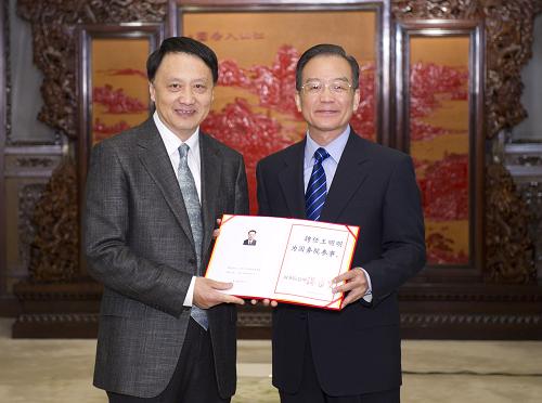 這是溫家寶向新聘任的國務(wù)院參事王明明頒發(fā)聘書。 新華社記者黃敬文攝