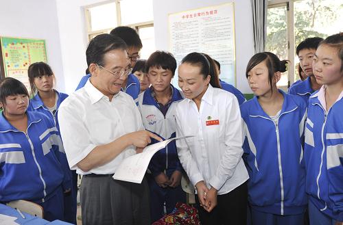9月10日是第26個教師節(jié),中共中央政治局常委、國務(wù)院總理溫家寶與明年畢業(yè)的北京師范大學(xué)首批免費師范生代表一起來到河北省興隆縣六道河中學(xué),看望廣大師生,聽中學(xué)教師上課,并與中小學(xué)教師和免費師范生代表座談。 這是溫家寶與九年級2班的同學(xué)一起上完語文課外閱讀課后,與師生交流。 新華社記者黃敬文攝