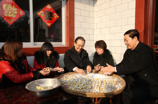 2月1日,農(nóng)歷臘月二十九,中共中央政治局常委、國(guó)務(wù)院總理溫家寶前往大別山腹地安徽金寨縣,看望農(nóng)民群眾,了解大別山革命老區(qū)經(jīng)濟(jì)社會(huì)發(fā)展情況,同基層干部群眾共度新春佳節(jié)。這是溫家寶總理在桃?guī)X鄉(xiāng)趙院村與村民圍坐在一起包圓子。新華社記者 姚大偉 攝