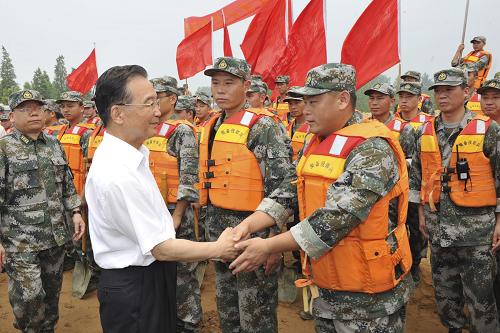 7月24日,中共中央政治局常委、國務院總理溫家寶在安徽檢查指導淮河防汛抗洪工作。這是在淮河大堤旁的防汛石料儲備點,溫家寶慰問在抗洪第一線的解放軍、武警和民兵預備役官兵。新華社記者 黃敬文 攝