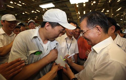 7月25日至27日,中共中央政治局常委、國務(wù)院總理溫家寶到吉林考察。這是7月26日,溫家寶在一汽轎車股份有限公司考察時應(yīng)一位工人的要求,在他的工作服上簽名留念。 新華社記者姚大偉攝