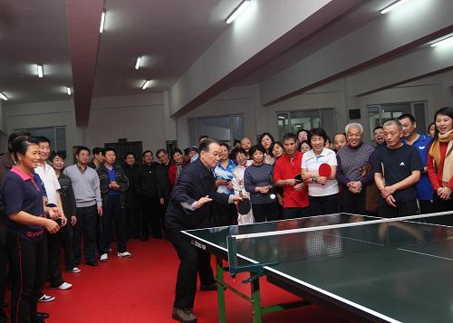 這是1月1日,溫家寶在大慶市黎明社區(qū),看望正在社區(qū)活動中心參加文體活動的居民并和他們一起打乒乓球。 新華社記者蘭紅光攝