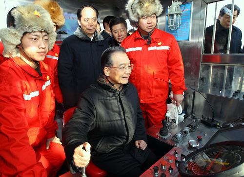 元月1日至2日,中共中央政治局常委、國務(wù)院總理溫家寶來到黑龍江省大慶市和齊齊哈爾市,冒著嚴(yán)寒,登上鉆井平臺,深入企業(yè)、社區(qū)和農(nóng)戶家中,親切看望慰問廣大干部群眾,代表黨中央、國務(wù)院向大家致以新年的問候。這是1月1日,溫家寶在大慶油田“新時期鋼鐵鉆井隊”15152鉆井隊司鉆房,操控鉆機控制手柄。新華社記者 蘭紅光 攝
