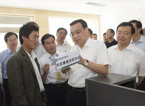 8月17日至19日,中共中央政治局常委、國務(wù)院總理李克強到甘肅定西、蘭州考察。這是8月18日,李克強在岷縣農(nóng)村信用社考察金融支持農(nóng)業(yè)、小微企業(yè)和災(zāi)后重建情況。新華社記者 李學(xué)仁 攝