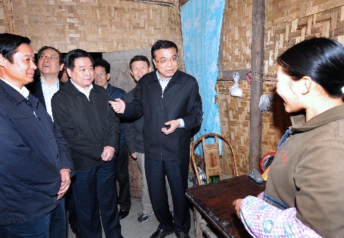 這是10月26日,李克強(qiáng)在漩口鎮(zhèn)油輾村過渡性自建房里向村民汪娟了解生活情況。新華社記者 馬占成 攝