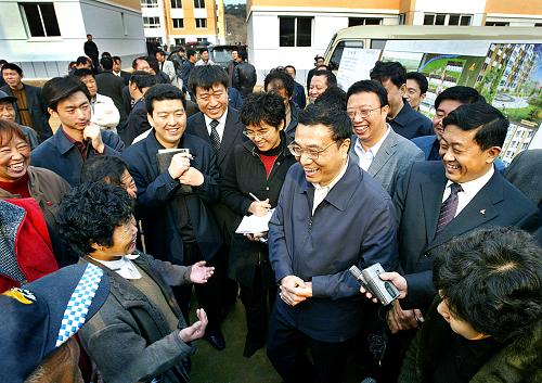 2005年11月3日,李克強(qiáng)在撫順與棚戶區(qū)改造搬進(jìn)新居的群眾親切交談。新華社發(fā)
