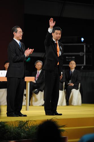 3月25日,現(xiàn)年57歲的梁振英(右)勝出后揮手致意。新華社記者 呂小煒 攝