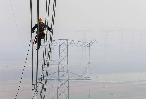 11月27日,技術(shù)人員在“淮上線”特高壓輸電工程江蘇淮安盱眙縣境內(nèi)的線路上進(jìn)行驗(yàn)收作業(yè)。近日,我國(guó)首條跨淮河流域特高壓工程“淮南——南京——上?!?000千伏特高壓工程江蘇段項(xiàng)目建設(shè)竣工?!盎瓷暇€”特高壓工程是國(guó)家大氣污染防治行動(dòng)計(jì)劃的重點(diǎn)輸電通道之一,全長(zhǎng)759千米,橫跨安徽、江蘇、上海三省市,計(jì)劃于2016年投運(yùn)。 11月27日,技術(shù)人員在“淮上線”特高壓輸電工程江蘇淮安盱眙縣境內(nèi)的線路上進(jìn)行驗(yàn)收作業(yè)。近日,我國(guó)首條跨淮河流域特高壓工程“淮南——南京——上海”1000千伏特高壓工程江蘇段項(xiàng)目建設(shè)竣工?!盎瓷暇€”特高壓工程是國(guó)家大氣污染防治行動(dòng)計(jì)劃的重點(diǎn)輸電通道之一,全長(zhǎng)759千米,橫跨安徽、江蘇、上海三省市,計(jì)劃于2016年投運(yùn)。